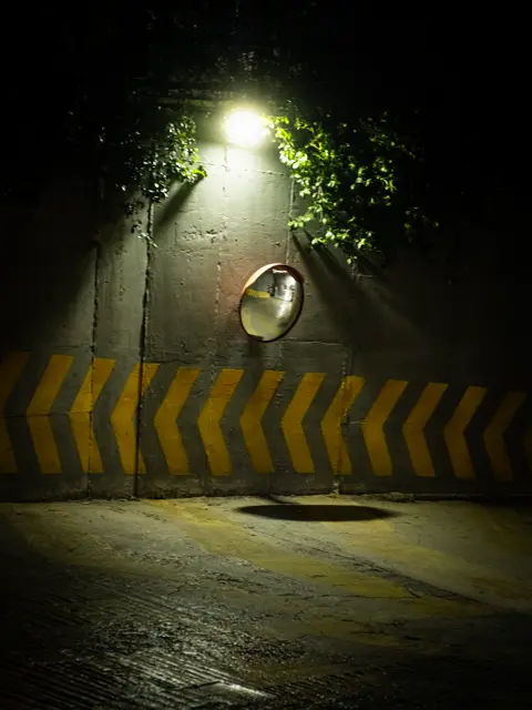 A street light over a wet road barrier at night