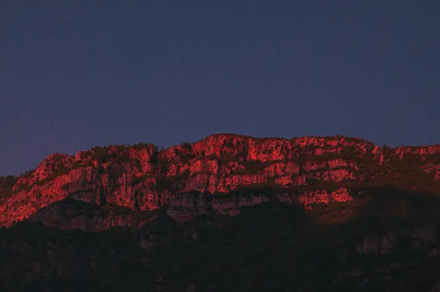A mountain ridge glowing red at dusk