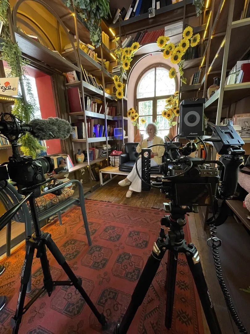 Camera and lights set up in a library with sunflowers